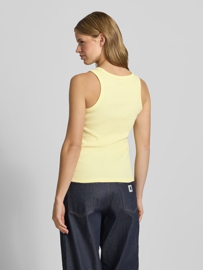 Frauenmodel trägt Slim Fit Top aus Baumwoll-Mix Modell 'MAY' von Pieces in Gelb, unifarben, Jersey-Textur, Ganzkörperansicht Rückansicht.