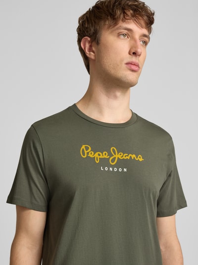 Männermodel trägt Regular Fit T-Shirt aus reiner Baumwolle Modell 'EGGO' von Pepe Jeans, Optik: Unifarben, Label-Print, Nahaufnahme Oberkörper.