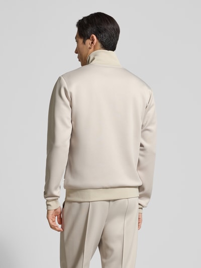 Męski model nosi Sweatjacke mit Logo-Print Modell 'Ballier' od Les Deux, materiał z dodatkiem stretchu, prosty krój, beżowy kolor, gładka tekstura, widoczne ściągacze i boczne kieszenie; widok całej sylwetki od tyłu.