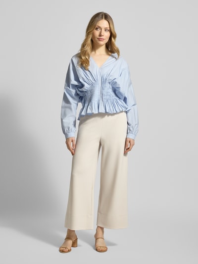 Frauenmodel trägt Hose mit elastischem Bund Modell 'PALINA 6/8 SPORT' von Raffaello Rossi, weites Bein, verkürzte Passform, helle Farbe, Ganzkörperansicht von vorne.