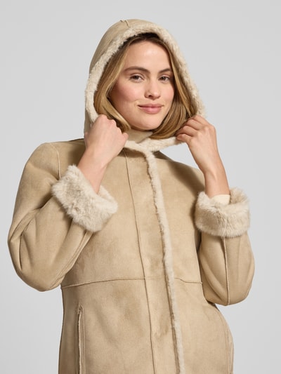 Kobiece model prezentuje Wendemantel mit Kapuze und Eingrifftaschen od PETITE M., beżowy, z futerkiem, regular fit, zbliżenie górnej części ciała.
