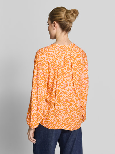 Frauenmodel trägt Damenbluse im Allover-Look mit V-Ausschnitt von Emily Van den Bergh in Orange, reine Viskose, Ganzkörperansicht Rückansicht.