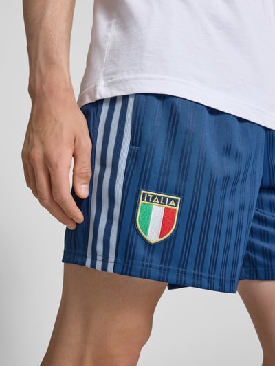 Männermodel trägt Loose Fit Trikot-Shorts mit FIGC-Applikation von adidas Originals, Optik:Allover-Muster, Jacquard, Nahaufnahme Oberschenkel.
