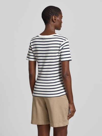 Kobiece model prezentuje Slim Fit T-Shirt aus reiner Baumwolle von Tommy Hilfiger, efekt: jednolity kolor, krój slim fit, wyhaftowane logo, dekolt w serek, krótki rękaw, wykończenie materiału: dżersej, materiał: czysta bawełna, widok całej sylwetki z tyłu.