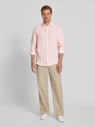 Männermodel trägt Regular Fit Leinenhemd aus reinen Leinen Modell 'Lawrence' von Jack & Jones Premium in Hellrosa, Ganzkörperansicht von vorne, Kentkragen, langärmelig, Knopfleiste, glatte Textur, Leinenstoff, mit beigefarbener Hose und weißen Sneakern, Kontext: Herrenhemd, Rückenlänge 74 cm, Schulterbreite 45 cm, Ärmellänge 66 cm.