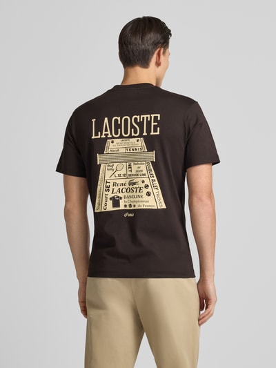 Męski model nosi Regular Fit T-Shirt aus reiner Baumwolle Modell 'LOURD' od Lacoste, czarne, logo-stitching, krótki rękaw, widok całej sylwetki od tyłu.