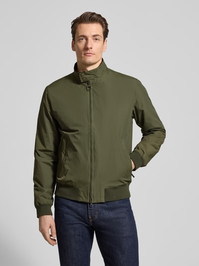 Mannenmodel draagt Regular fit blouson met opstaande kraag model 'Royston' van Barbour, effen olijfgroen, lange mouwen, zijzakken met rits, labeltekst, ribboorden, tweewegrits, nikkel oogjes, geheel van voren.