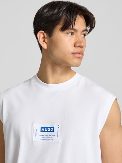 Männermodel trägt Regular Fit Tank Top aus reiner Baumwolle Modell 'NURAZAK' von Hugo Blue in Weiß mit Rundhalsausschnitt, Nahaufnahme Oberkörper.