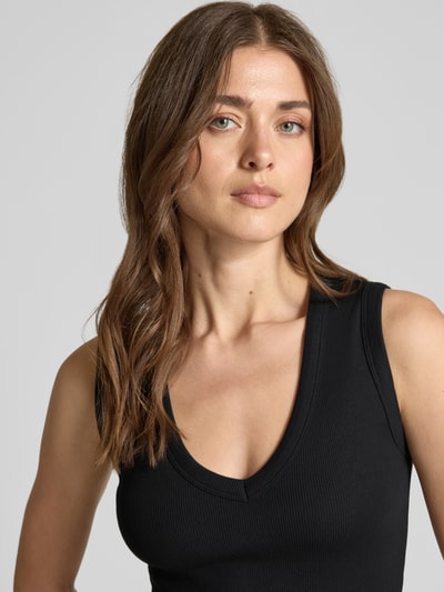Frauenmodel trägt Slim Fit Tank Top aus Baumwoll-Mix Modell 'CHLOE' von Vero Moda in Optik: Unifarben mit V-Ausschnitt, breite Träger, Materialverarbeitung: Ripp, Nahaufnahme Oberkörper.