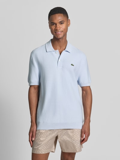 Mannelijk model draagt Regular Fit poloshirt uit puur katoen van Lacoste, look: effen kleuren, gestikt logo, polokraag, korte mouw, mouwboord en rompzoom geribd, materiaalverwerking: dwarsgebreid materiaal, Ganzkörperansicht von voren.