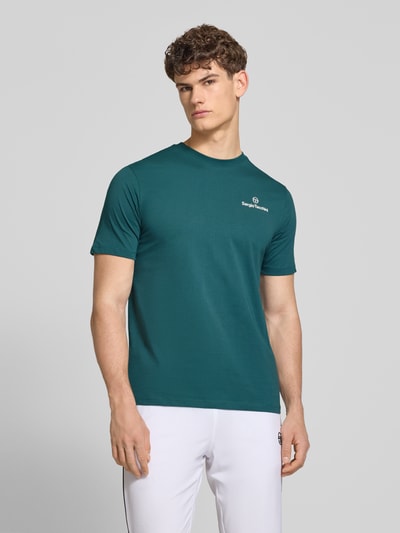 Männermodel trägt Regular Fit T-Shirt mit Logo-Print von Sergio Tacchini in Dunkelgrün, reine Baumwolle, Rundhalsausschnitt, Ganzkörperansicht von vorne.