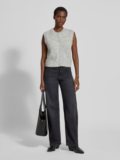 Frauenmodel trägt Regular Fit Strickweste aus Woll-Mix Modell 'LULU' von Selected Femme in Melange-Optik mit Crew-Neck, einreihiger Knopfleiste sowie geripptem Rumpfabschluss, Strick-Textur in Grautönen, Ganzkörperansicht von vorne.