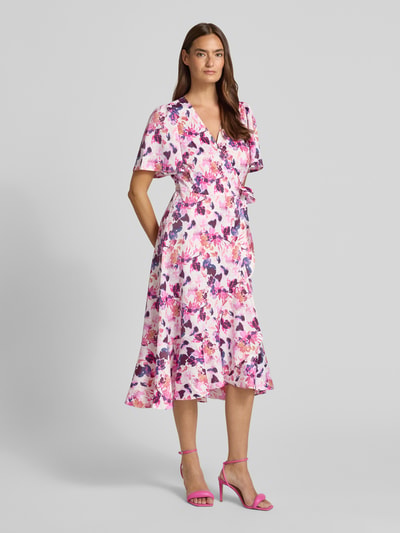 Frauenmodel trägt Wickelkleid in Midilänge Modell 'Thea' von YAS mit Floraler-Print, Elastischer-Material-Mix, Tailliert, Ganzkörperansicht von vorne.