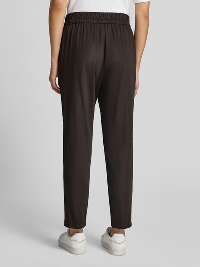 Frauenmodel trägt Hose mit elastischem Bund und Eingrifftaschen von Marc Cain in Dunkelbraun, Material-Mix, Regular Fit, Ganzkörperansicht Rückansicht.