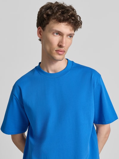 Männermodel trägt Oversized T-Shirt mit Rundhalsausschnitt von Lindbergh aus Reine Baumwolle in Blau, Ganzkörperansicht von vorne. Herren T-Shirt, oversized, Rückenlänge in Größe M: 69 cm.