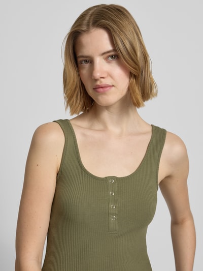 Frauenmodel trägt Slim Fit Tank Top aus Bio-Baumwoll-Mix Modell 'KITTE' von Pieces, Optik: Unifarben, Ripp, Henley-Ausschnitt, Knopf-Detail, breite Träger, Nahaufnahme Oberkörper.
