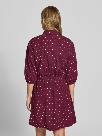Vrouwenmodel draagt Tailliertes Freizeitkleid aus reiner Baumwolle van MOP DENIM in bordeaux met witte stippen, getailleerde fit, hemdkraag, 3/4-mouw met elastische boorden, uitlopende rok, zichtbare tailleband, katoenstructuur, geheelopname rugaanzicht.
