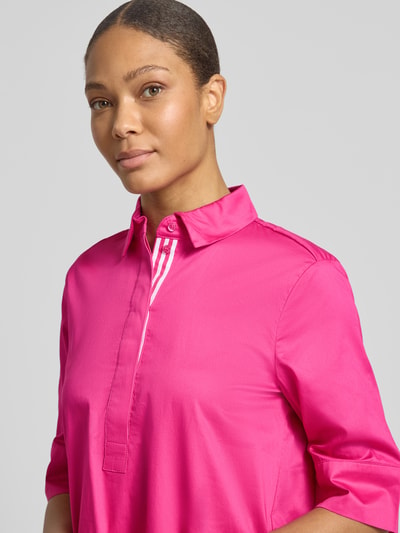 Frauenmodel trägt Knielanges Hemdblusenkleid mit Eingrifftaschen von Christian Berg Woman in Pink, reine Baumwolle, Nahaufnahme Oberkörper.