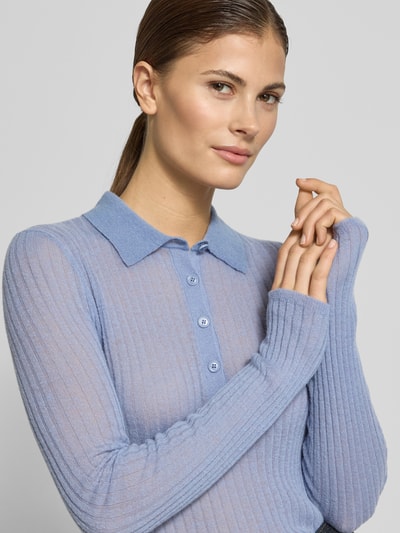 Vrouwenmodel draagt Slim Fit gebreide pullover uit scheerwolmix Model 'FUGENEL' van BOSS Orange, effen, gestreepte look, polokraag, lange mouw, labelstitching, geribde mouw- en rompzoom, gebreide verwerking, close-up van het bovenlichaam.