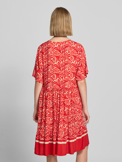 Frauenmodel trägt knielanges Kleid aus Viskose Modell 'Me44la' von ZABAIONE in Rot mit Allover-Muster, lockere A-Linie, Ganzkörperansicht Rückansicht.