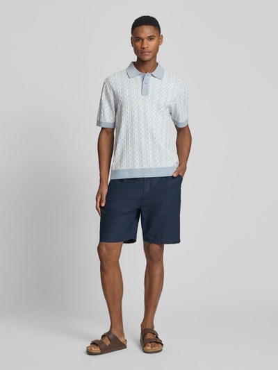 Männermodel trägt Regular Fit Poloshirt mit Knopfleiste Modell 'Tamian' von Drykorn aus Reine Baumwolle, Ganzkörperansicht von vorne. Rückenlänge bei Größe M: 66 cm.