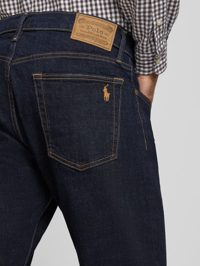 Männermodel trägt Straight Fit Jeans mit Raw Denim Optik von POLO RALPH LAUREN, dunkelblau, 5-Pocket-Design, Nahaufnahme Rückansicht.
