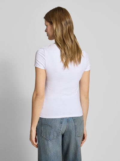Kobiece model prezentuje Slim Fit T-Shirt mit Rundhalsausschnitt od REVIEW, elastyczna mieszanka bawełny, długość tyłu 52 cm, krój slim fit, okrągły dekolt, krótki rękaw, widok całej sylwetki z tyłu.