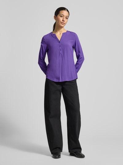 Vrouwenmodel draagt Regular Fit Blouse uit zuivere viscose met tuniekhals van Christian Berg Woman, effen paars, met knoopsluiting, met lange mouwen, ruglengte maat 36: 64 cm, mouwlengte maat 36: 60 cm, volledige lichaamsaanzicht van voren.
