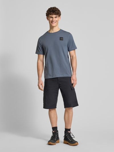 Mannelijk model draagt T-shirt uit katoenmix model 'EVOLUTION' van The North Face, regular fit, labelprint, rondkraag, volledige lichaamsaanzicht van voren