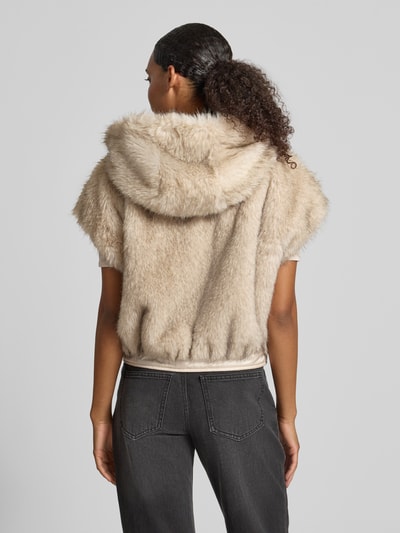 Frauenmodel trägt Regular Fit Weste aus Kunstfell von Marc Cain in Beige mit Kapuze, flauschige Textur, Ganzkörperansicht Rückansicht. Damen Weste von Marc Cain.