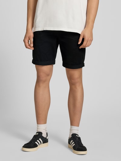 Männermodel trägt Shorts mit Gürtel Modell 'MIKE' von Redefined Rebel, schwarze Farbe, Eingrifftaschen, Regular-Fit, Nahaufnahme Oberschenkel, Kontext: Bundweite bei Größe M 43 cm, Innenbeinlänge 21 cm.