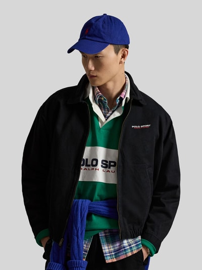 Männermodel trägt Regular Fit Blouson aus reiner Baumwolle von Polo Ralph Lauren in Schwarz, mit Umlegekragen und Logo-Stitching, Ganzkörperansicht von vorne.