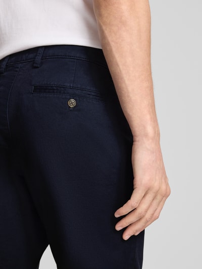 Männermodel trägt Slim Fit Chino mit Eingrifftaschen von GAP im Baumwoll-Elasthan-Mix, dunkelblau, Detailaufnahme Rückansicht.
