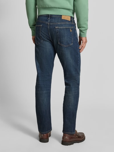 Männermodel trägt Straight Fit Jeans aus Baumwoll-Mix Modell 'HAMPTON' von Polo Ralph Lauren in dunklem Blau, Ganzkörperansicht Rückansicht. Herren Straight Fit Jeans von Polo Ralph Lauren.
