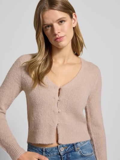 Frauenmodel trägt Slim Fit Strickjacke mit einreihige Knopfleiste Modell 'KERRY' von Only, Optik: Unifarben, V-Ausschnitt, langarm, Strick, Nahaufnahme Oberkörper.