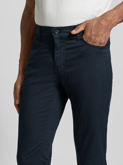 Männermodel trägt dunkelblaue Hose mit Eingrifftaschen Modell 'Chuck' von Brax, Baumwoll-Mix mit Lyocell-Anteil, Slim Fit, Nahaufnahme Oberkörper.