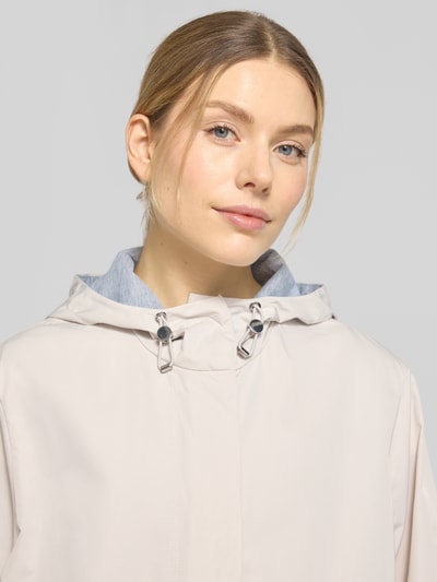 Modelka kobieca nosi Mantel mit Pattentaschen od WHITE LABEL, prosta forma, kaptur z troczkiem, elastyczne mankiety, jasny kolor, zbliżenie na górę sylwetki, szerokość w rozmiarze 36: 45 cm ramiona, 54 cm biust, długość pleców: 101 cm, długość rękawa: 59 cm