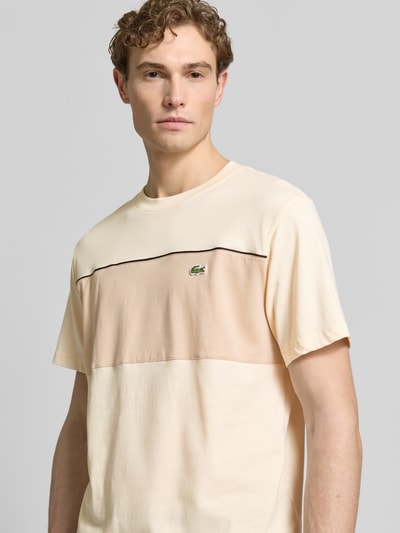 Männermodel trägt Regular Fit T-Shirt aus reiner Baumwolle von Lacoste in Two Tone Optik mit Label Patch; Nahaufnahme Oberkörper.