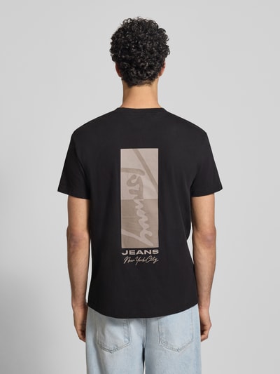Männermodel trägt Regular Fit T-Shirt aus reiner Baumwolle Modell 'SIGN BLOCK' von Tommy Jeans, Optik: Unifarben, Rücken-Print, Ganzkörperansicht Rückansicht.
