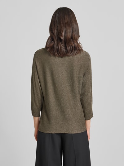 Modelka prezentuje Strickshirt aus Viskose-Mix mit 3/4-Arm von comma, mieszanka wiskozy, krój regular fit, efekt błyszczący, okrągły dekolt, rękaw o dł. 3/4, długość tyłu w rozmiarze 36 – 61 cm, długość rękawów w rozmiarze 36 – 50 cm, kolor oliwkowy, jednolita struktura, widok całej sylwetki z tyłu.