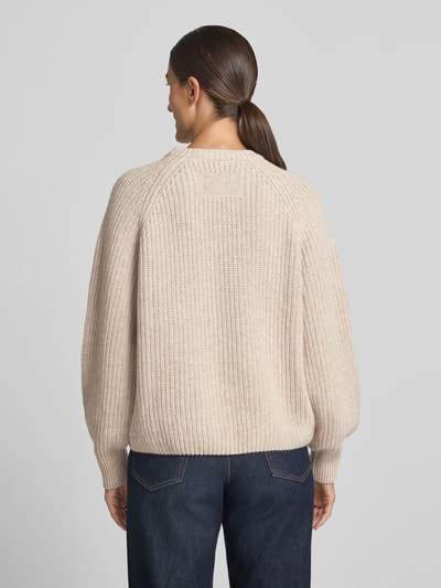 Frauenmodel trägt Loose Fit Pullover aus Woll-Mix Modell 'RIB KNIT' von ARMEDANGELS in Beige mit grober Strickstruktur, Ganzkörperansicht Rückansicht. Damen Pullover