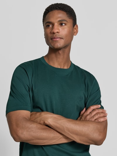 Männermodel trägt Regular Fit T-Shirt mit Logo-Stitching von MCNEAL, dunkelgrün, Reine Baumwolle, Rundhalsausschnitt, Nahaufnahme Oberkörper.