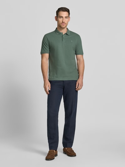 Męski model nosi Slim Fit Poloshirt mit Stitching von Jack & Jones Premium, czysta bawełna, krój slim fit, zapięcie na guziki, długość tyłu w rozmiarze M: 70 cm, widok całej sylwetki od przodu.