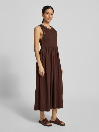 Frauenmodel trägt Midikleid mit Rundhalsausschnitt und Stitchings von Scotch & Soda, Reine Baumwolle, A-Linie, braun, Ganzkörperansicht von vorne. Rückenlänge bei Größe S: 125 cm, Brustweite bei Größe S: 37 cm.