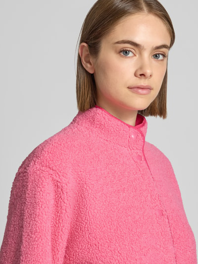 Frauenmodel trägt Teddyjacke mit Stehkragen Modell 'VERA' von JJXX in Pink, weiche Textur, lockere Passform, Nahaufnahme Oberkörper.