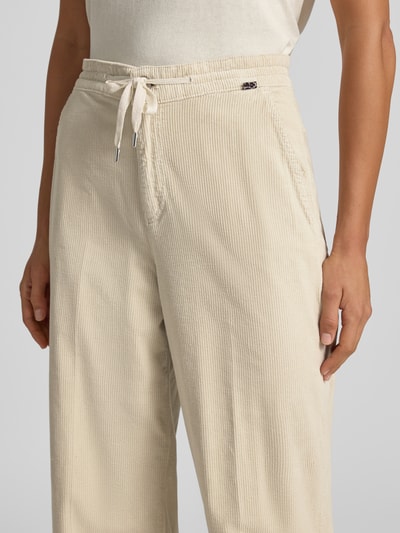 Vrouwenmodel draagt Cordhose mit Kordelzug und Eingrifftaschen van Marc Cain, katoenmix met stretch, wide leg fit, Band met tunnelkoord, steekzakken, achterzakken, bandwijdte maat 36: 42 cm, binnenbeenlengte maat 36: 84 cm, detailopname taille en bovenbenen.