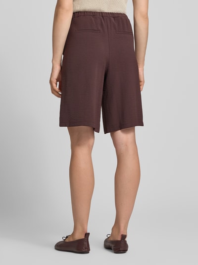 Frauenmodel trägt Bermudas mit Gürtel und französischen Eingrifftaschen von zero in Braun, lockerer Schnitt, elastischer Bund, Detailaufnahme Rückansicht.