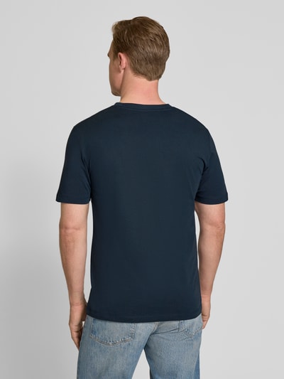 Męski model nosi Regular Fit T-Shirt aus reiner Baumwolle von s.Oliver RED LABEL, kolor jednolity, krój regular fit, okrągły dekolt, krótki rękaw, jersey, czysta bawełna, widok całej sylwetki od tyłu.