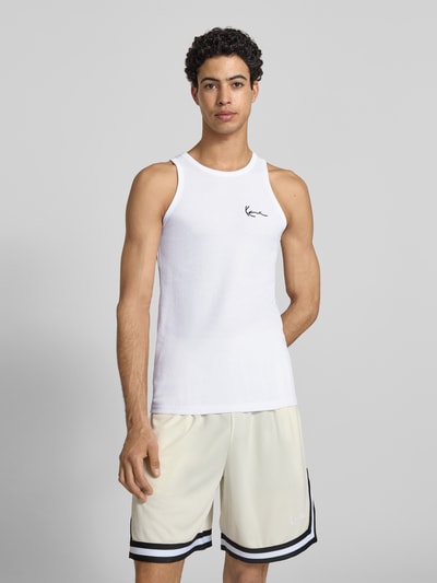 Männermodel trägt Slim Fit Top mit Logo-Stitching von KARL KANI aus Baumwoll-Mix, weiß, Rundhalsausschnitt, Ganzkörperansicht von vorne. Rückenlänge bei Größe M: 68 cm.