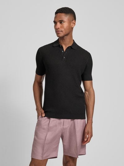 Männermodel trägt Slim Fit Poloshirt aus Viskose-Mix von Antony Morato, Strick-Optik, schwarz, Kurzärmelig, Ganzkörperansicht von vorne.